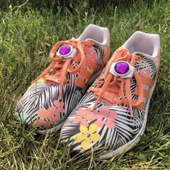 pair of shoes in grass with knotbot shoelace locks keeping shoes tied