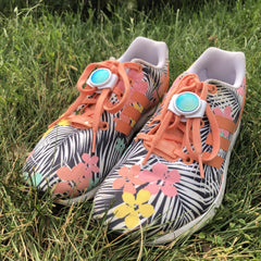 pair of shoes in grass with knotbot shoelace locks keeping shoes tied